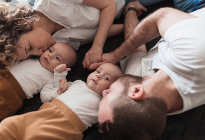 Happy parents cuddling with their newborn sons